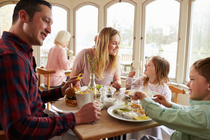 Family Enjoying Meal In Restaurant Together